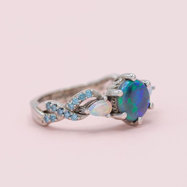 Black and white opals come together with aquamarine accents to create a wintry, fantastical engagement ring.