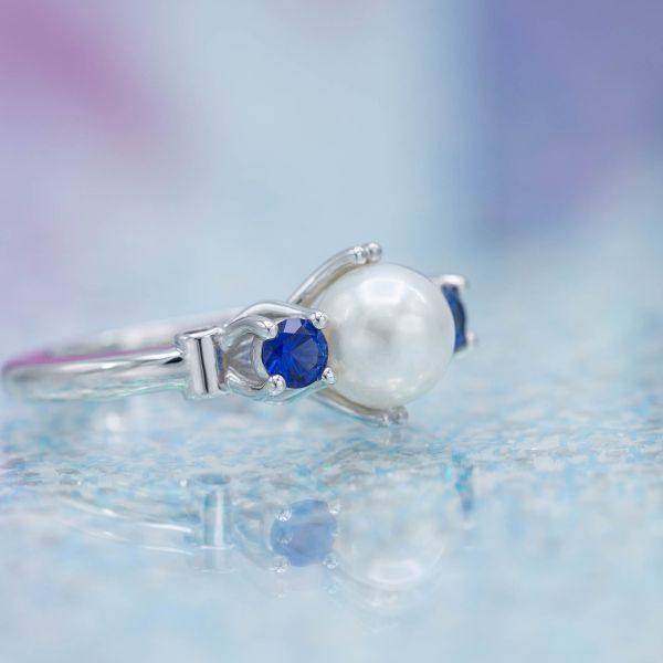 A sleek three stone setting with pearl and blue sapphires.