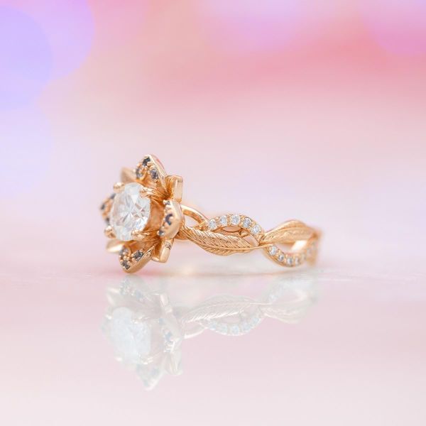 A moissanite sits in the center of this rose gold lotus ring.