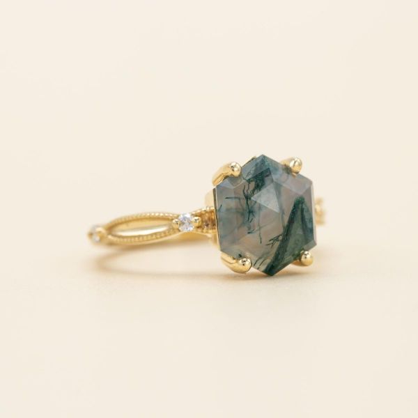 Hexagon cut moss agate and diamond accents are set in a unique yellow gold band.