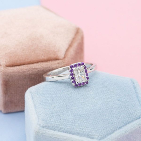 A moissanite center stone is surrounded by a halo of amethysts.