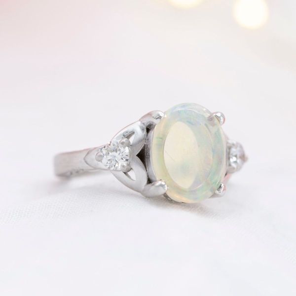 An opal sits in the center of this Batman inspired engagement ring.