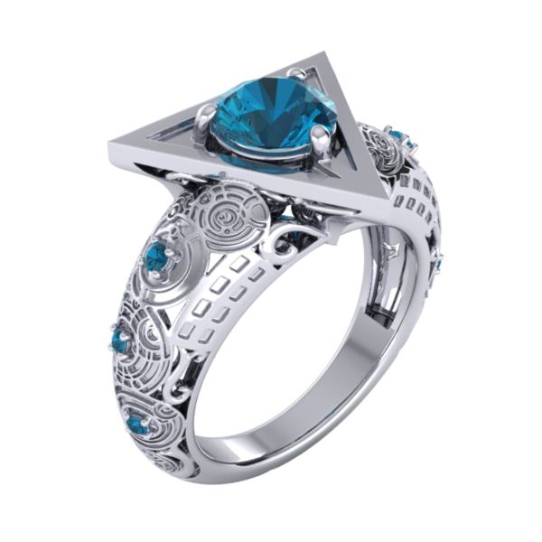 A round London blue topaz sits in a deathly hallows-inspired symbol while the band’s swirling circle patterns mirror the patterns etched into these matching engagement rings.