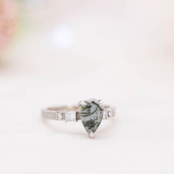 Pear cut white-and-green agate engagement ring, with a textured white gold setting.