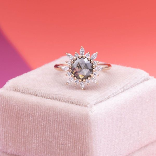 A diamond accented sunburst halo frames the salt and pepper diamond in Kate’s engagement ring while sun motifs bezel frame London blue topazes in Vincent’s matching band.