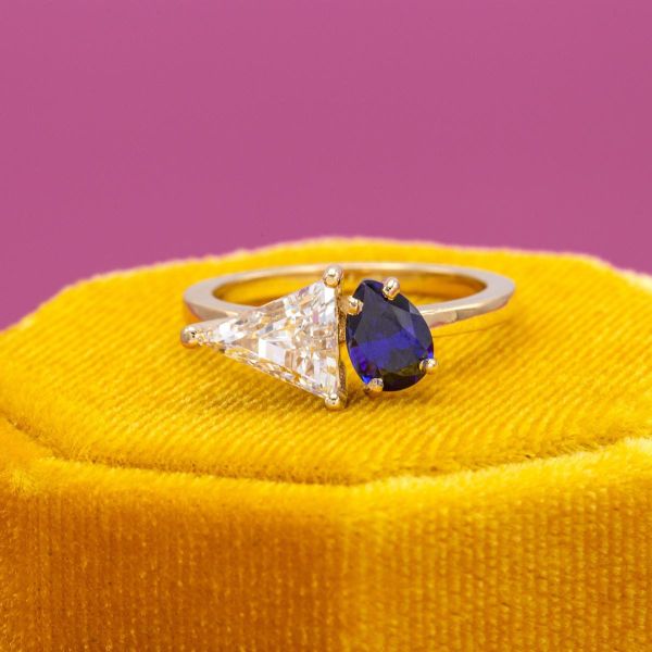 A diamond and a sapphire are at the heart of this yellow gold band.