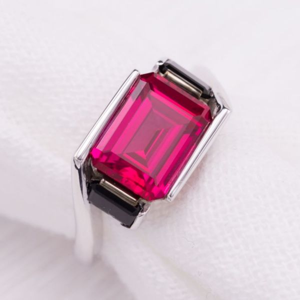 A modern play on the classic bypass setting, using large emerald cut gems and letting the band turn at sharp angles rather than the expected curves.