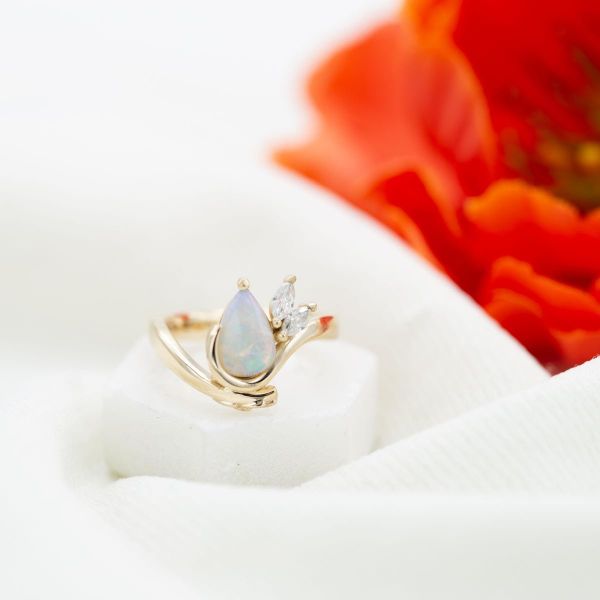 以海洋为灵感的订婚戒指，镶有marquise钻石，就像海洋的浪花在蛋白石中心飞溅。