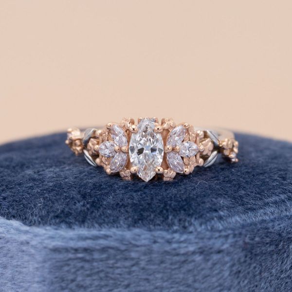 Different sized marquise cut diamonds make up the cluster of this mixed metal engagement ring.