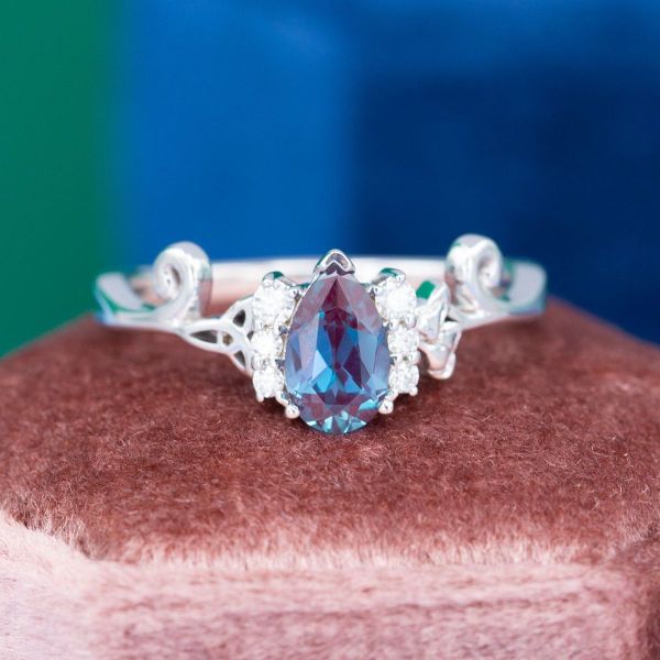Trinity knots hold a pear cut alexandrite in this white gold engagement ring.