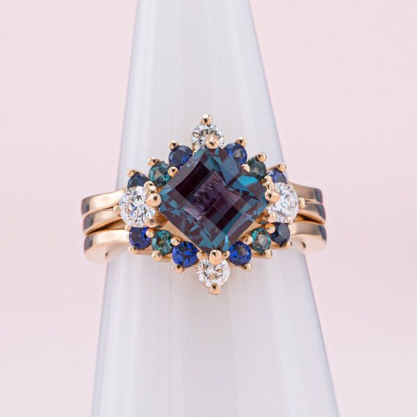A kite set, princess cut alexandrite is the center of this rose gold engagement ring with diamond accents.