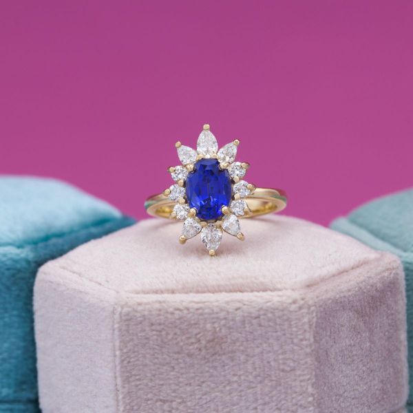Never say no to a dazzling halo! This brilliant oval lab-created sapphire was begging for a vintage style halo. We used round and pear cut diamond accents to create a breathtaking sunburst halo. The yellow gold prongs add a summery warmth to the ring.