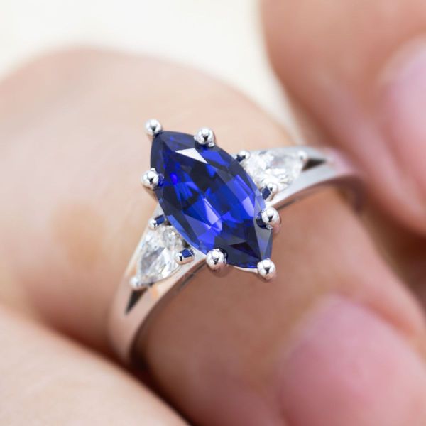 The classic sapphire and diamond pairing gets a contemporary makeover with bold shapes and clean lines. We set this stunning marquise lab-created sapphire and two lab-created diamond pears on a simple split shank white gold band that follows the shapes of the stones, allowing them to shine.