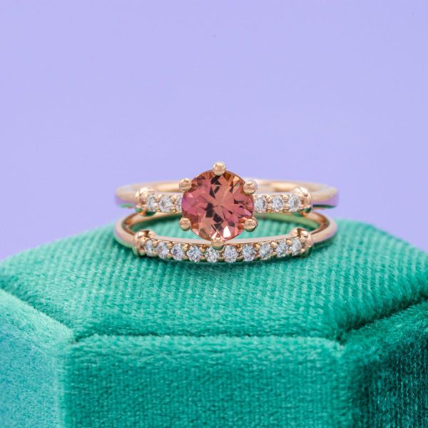 A rosy pink tourmaline engagement ring in yellow gold with diamond accents.