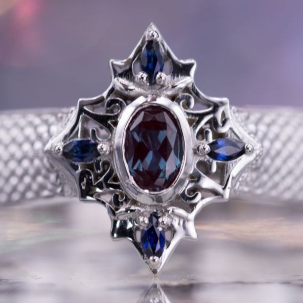 A classic vintage-inspired setting with marquise sapphires surrounding a bezel-set oval alexandrite.