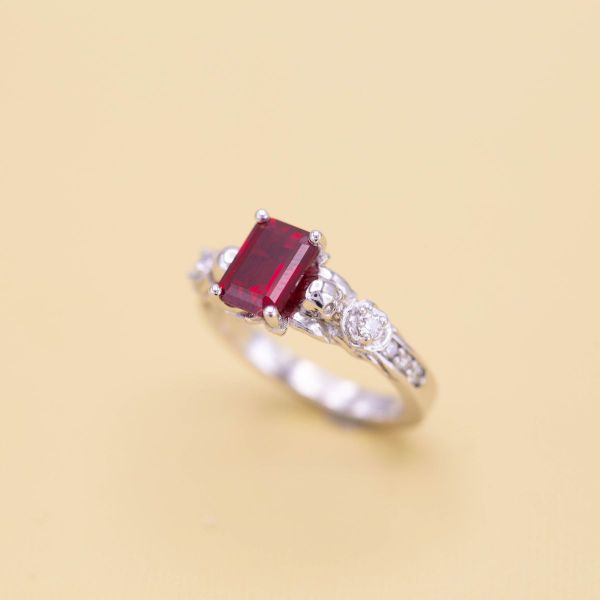 An emerald-cut ruby sits beautifully on a white gold band.