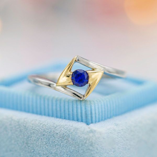 A round sapphire and lightning symbol center this Ms. Marvel inspired engagement ring.