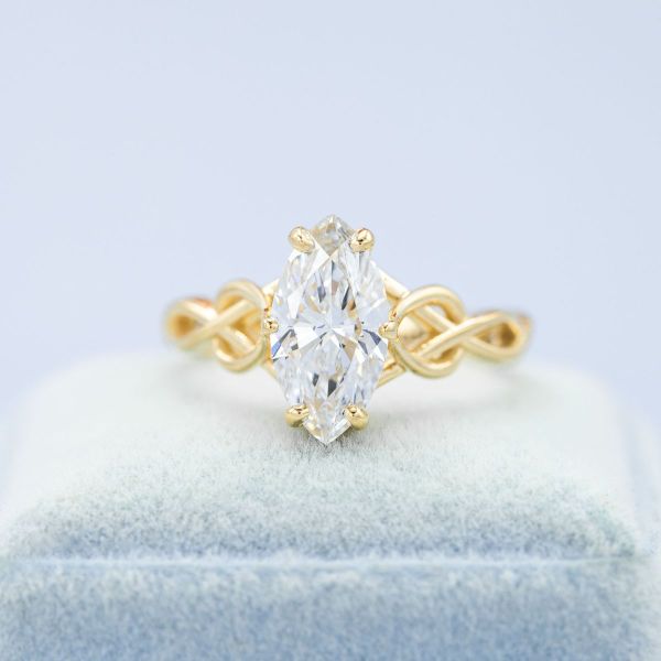 The woven band of this rope-inspired engagement ring looks lovely in yellow gold, and the lab diamond at its center brings sparkle to the setting.