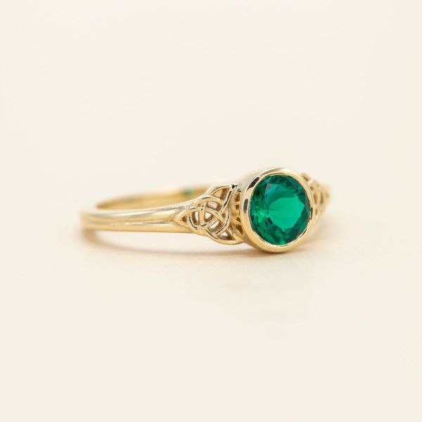 We’re charmed by the Irish green of the emerald center stone in this trinity knot engagement ring.