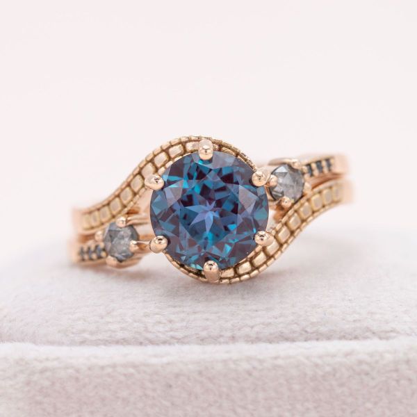 A sparkling blue lab created alexandrite is a shining center piece in this rose gold engagement ring.