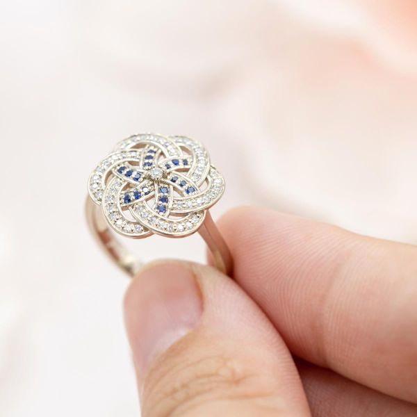 大胆的螺旋式订婚戒指设计，由蓝宝石和莫桑石交织而成。