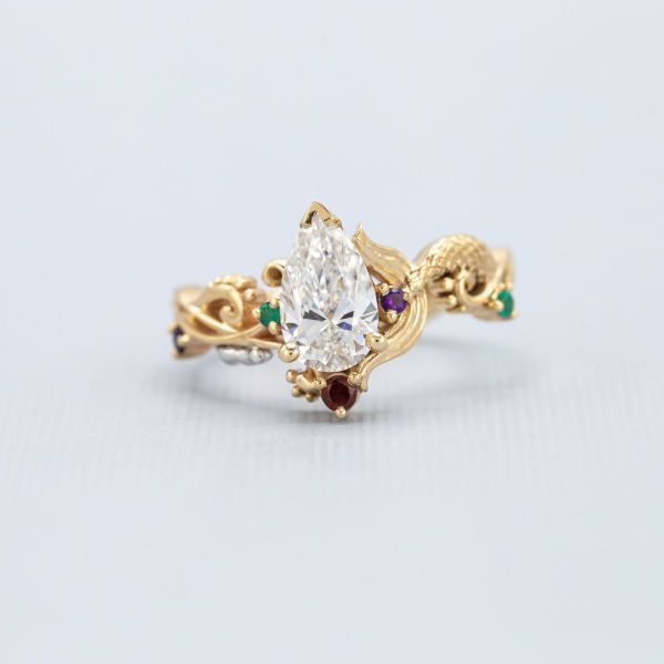 A diamond amidst a blast of colors in this mermaid themed ring