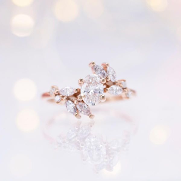 This ethereal engagement ring boasts lab created marquise diamond accents and an oval lab diamond at its center.