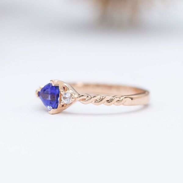 A trillion cut tanzanite is creatively set and paired with white sapphire accents.