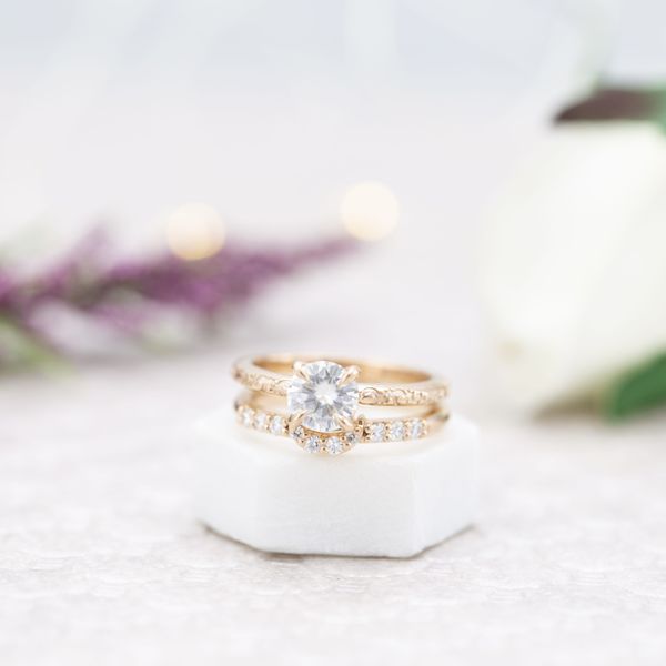 A stunning moissanite solitaire paired with a matching moissanite wedding band.