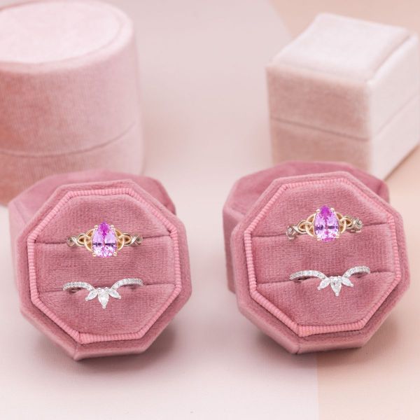 The light pink, lab-created sapphires are highlighted by rose gold trinity knots in these matching bridal sets with moissanite accents for extra sparkle.