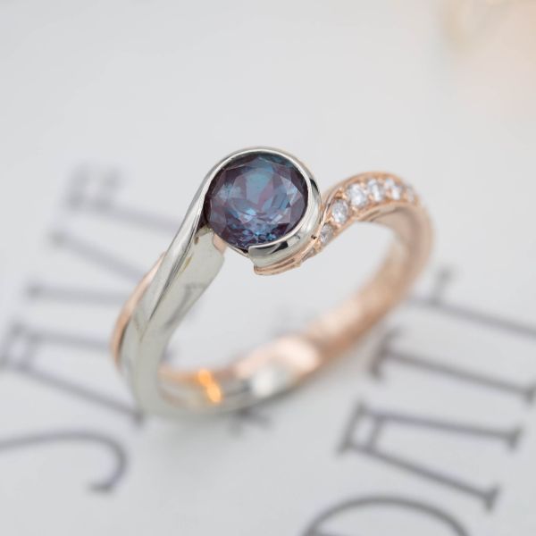 Asymmetric swoops of rose gold and white gold create a ton of movement around an alexandrite center stone