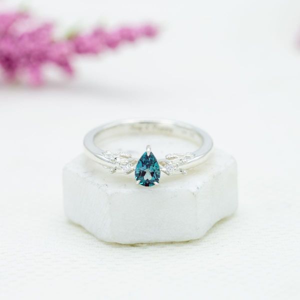 The alexandrite in the center of this white gold engagement ring has a fairly light saturation.