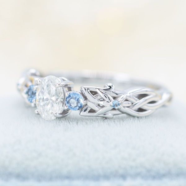 Subtle detailing inspired by Arwen’s Evenstar sits in the band of this diamond and aquamarine accented Lord of the Rings inspired engagement ring.