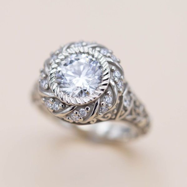 Elegant floral motifs and twisting movement bring life to this Edwardian inspired diamond ring.