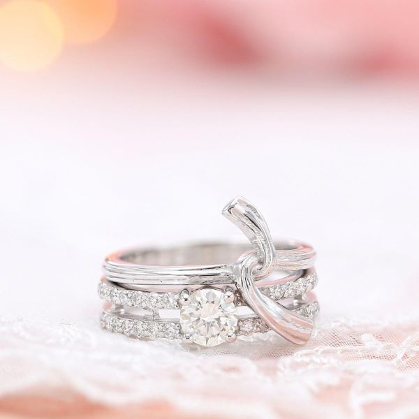 一个异想天开的新娘套装设计，将一枚经典的钻石订婚戒指与一枚形状像扭结的结婚戒指搭配在一起。