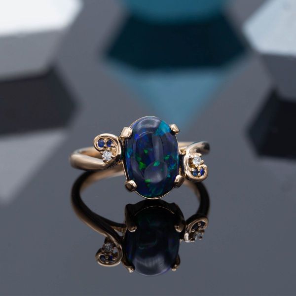 This Nightmare Before Christmas inspired engagement ring features an opal center stone with a band resembling the iconic Spiral Hill.