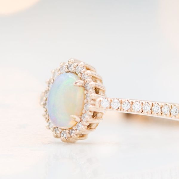 This ring's center stone is a cabochon cut opal with a flat bottom and a domed, polished top.