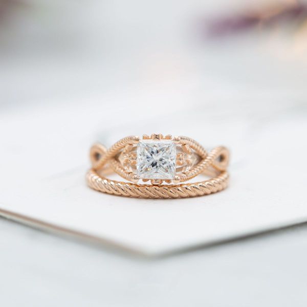 The diamond center and accents of this bridal set complement the tightly woven mixed metal bands and anchor details of these nautical rope-inspired rings.
