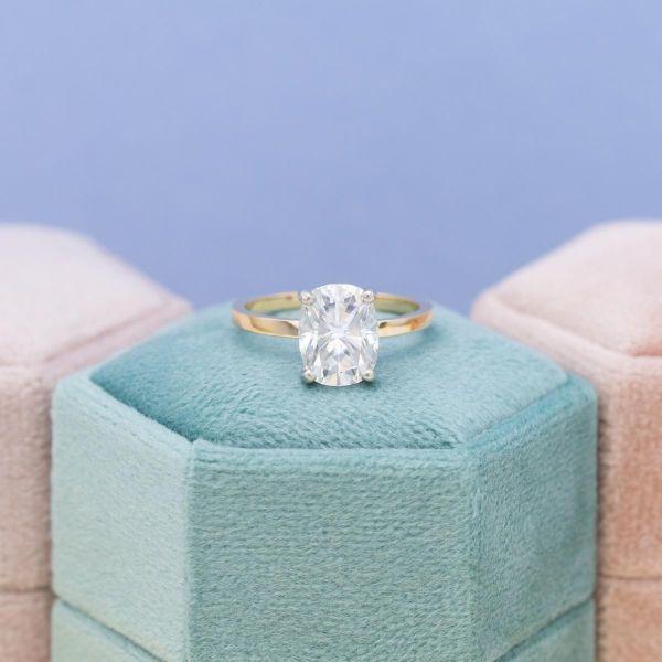Another oval moissanite in a simple yellow gold solitaire setting.
