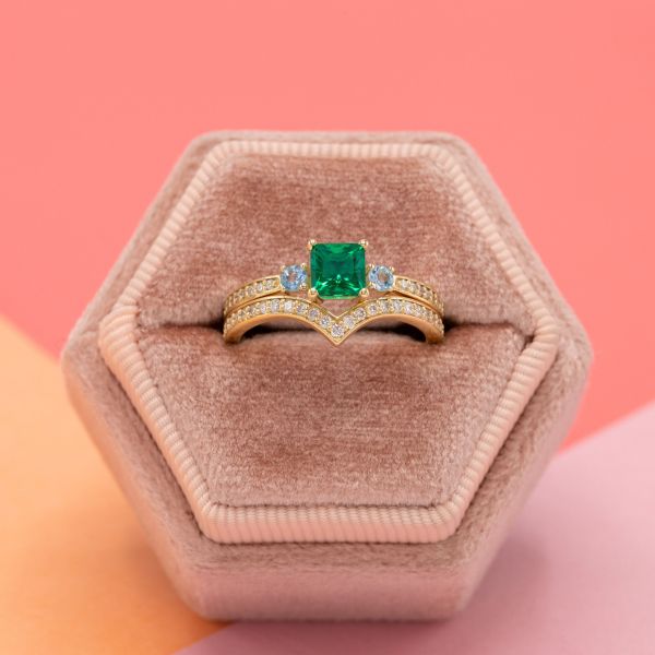 The emerald in this yellow gold engagement ring has a medium saturation.