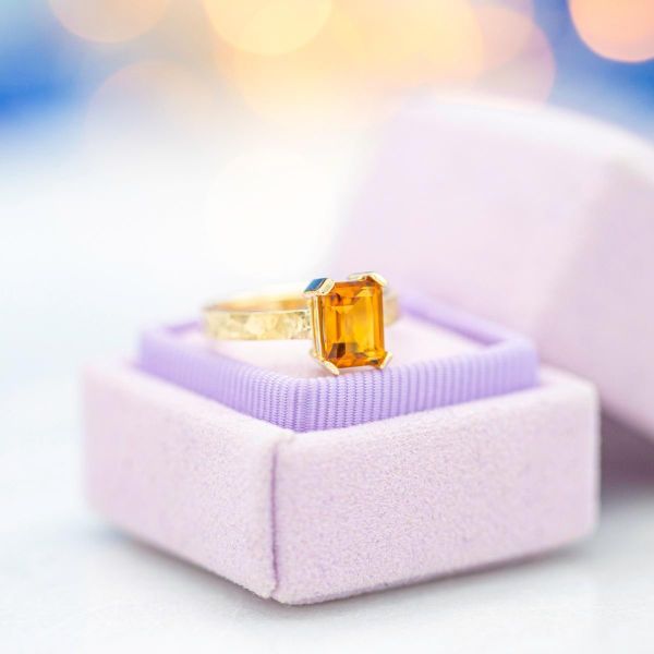 This engagement ring features a rich orange-yellow citrine set in a hammered gold band.