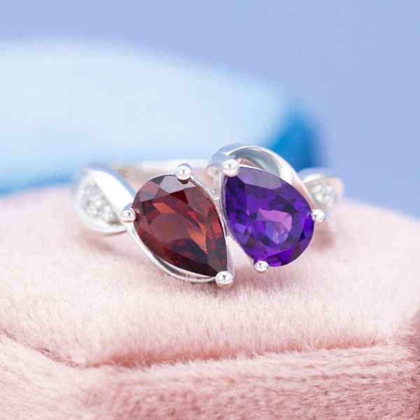 An amethyst and garnet mozambique sit in a toi et moi setting styled engagement ring.