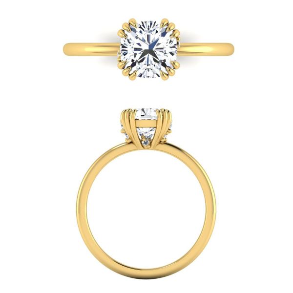 Four triple-claw prongs hold a solitaire cushion cut moissanite while more moissanites hide between the prongs in this engagement ring.