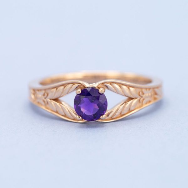 Amethyst and rose gold come together in this split-shank engagement ring with wing-like details.