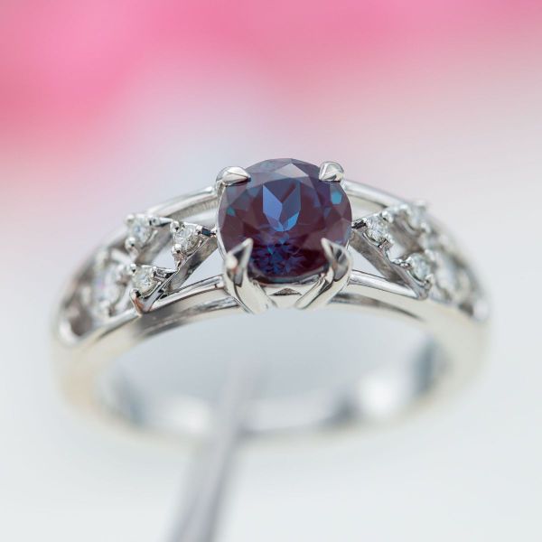 A piercing purple alexandrite stone centers this white gold engagement ring which features four Triforce inspired designs.