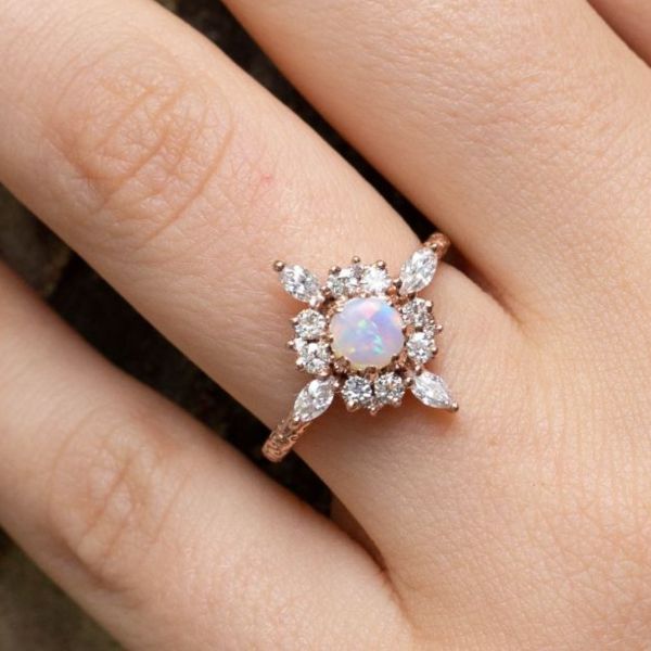 一枚令人惊叹的蛋白石订婚戒指，带有独特的日冕光环和细长的罗盘点。