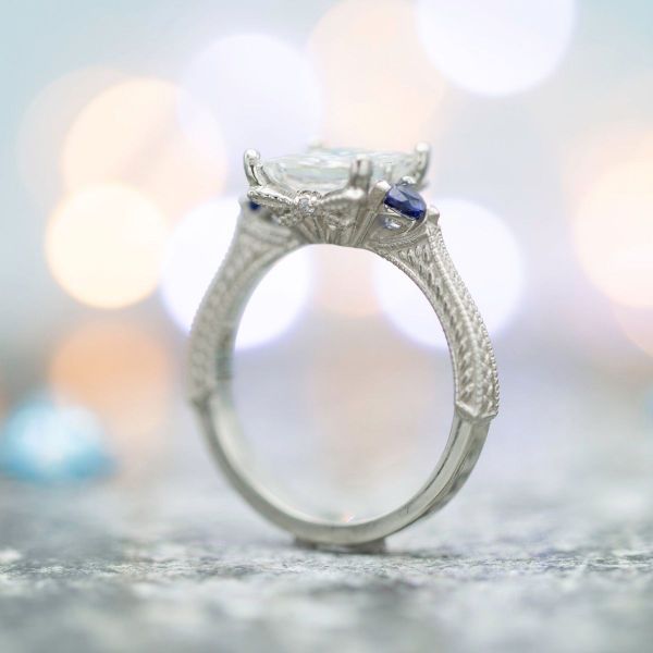 This princess cut moissanite sits on a detailed white gold band with a hidden dragonfly beneath the stone.