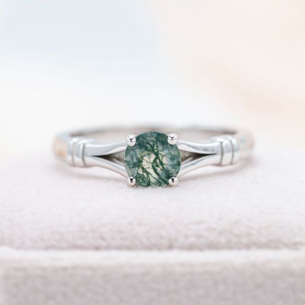 The gap created by the split-shank band holds a special meaning in this moss agate engagement ring.