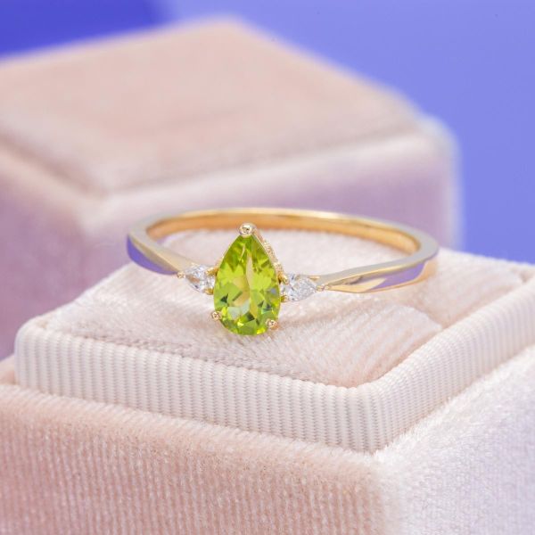 This yellow gold band features a peridot with two marquise side diamonds.