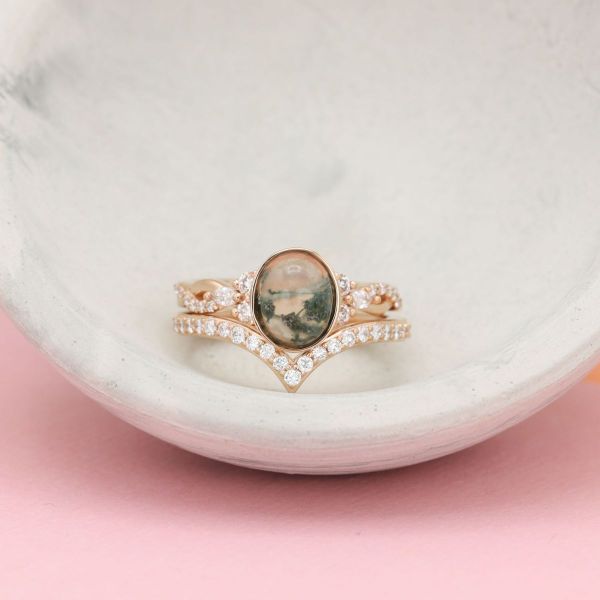 A cloudy oval moss agate engagement ring in yellow gold with diamond accents.